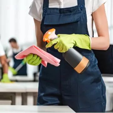 A cleaner is seen vacuuming an office. The best office cleaning in central Illinois is done by Corporate Clean.