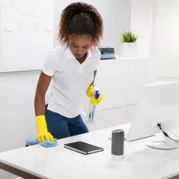 A cleaner is seen vacuuming an office. The best office cleaning in central Illinois is done by Corporate Clean.