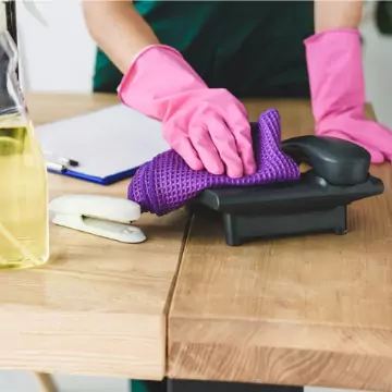A worker disinfects a telephone. Corporate Clean is the best of the Cleaning Companies in Dunlap IL.