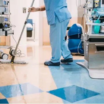 A worker is seen cleaning a floor in a medical setting. Corporate Clean provides Healthcare Cleaning in Washington IL