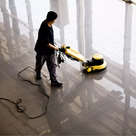 A female professional cleaner using a floor waxer to help keep a floor shiny and clean in Peoria, IL