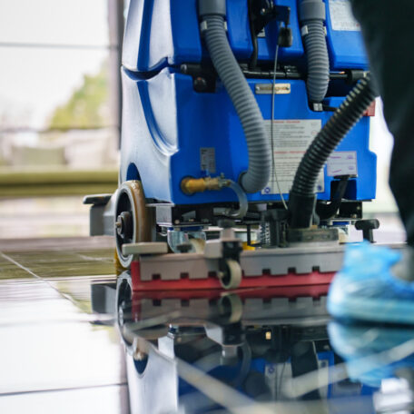Worker cleaning office lobby floor with machine in East Peoria IL business