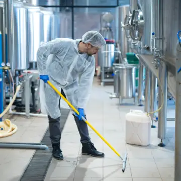 Industrial Cleaning vs Office Cleaning: How the Two are Different 2 A member of Corporate Clean sweeps floors in both Industrial Cleaning vs Office Cleaning scenarios