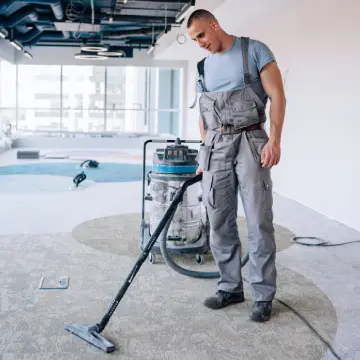 Preparing a Facility for Post-Construction Cleaning 2 A man vacuums while Preparing a Facility for Post-Construction Cleaning